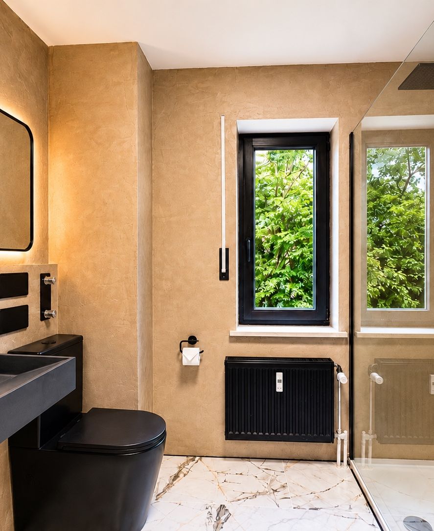 Badezimmer nach der Sanierung mit bodengleicher Dusche und dunklem Waschtisch